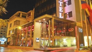 A hotel with a glass facade, a visible entrance, and a flag outside. - Hotel Ankara (Vina del Mar)