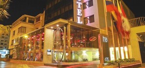 A hotel with a glass facade, a visible entrance, and a flag outside. - Hotel Ankara (Vina del Mar)