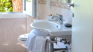 A bathroom with a white sink, a mirror, and a window. - Hotel Piccolo Mondo (Camaiore)