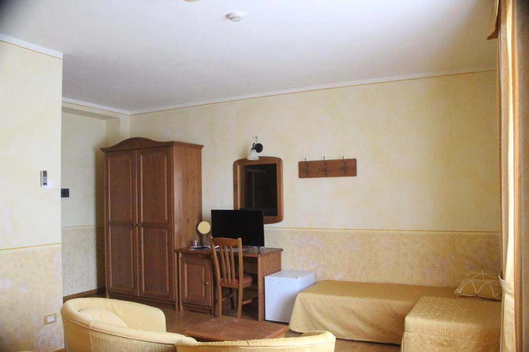 A room with a bed, a desk with a computer, a chair, and a wardrobe.