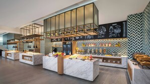 Una barra de desayuno moderna con encimeras de mármol y una selección de alimentos.