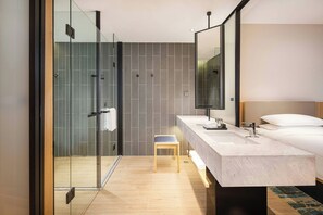 A modern bathroom with a glass shower enclosure, a wooden bench, a large mirror, and a marble sink. - Fairfield By Marriott Taiyuan South (Taiyuan)