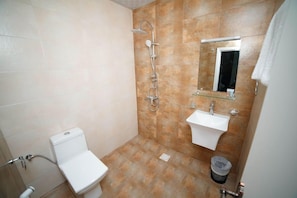A bathroom with a toilet, a shower, a sink, and a mirror. - Oyo 112 Star Emirates Downtown (Salalah)