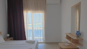 A hotel room with a bed, a desk, a mirror, and a window with curtains. - Vraja Marii Eforie Nord (Eforie)