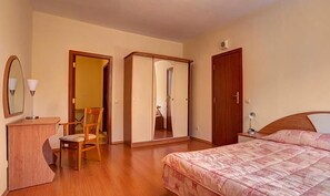 A bedroom with a bed, a chair, a desk, a wardrobe, and a mirror. - Apartments Flora (Samokov)