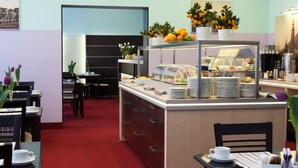 A breakfast area with a buffet counter, dining tables, and chairs. - Centrum Dikul (Wroclaw)