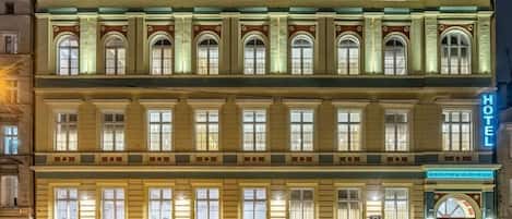 A multi-story hotel with a classic architectural style, featuring arched windows and a central entrance.
