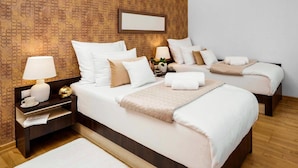 A hotel room with two beds, a nightstand with a lamp, a bedside table with a cup and papers, and a patterned wall. - Centrum Dikul (Wroclaw)