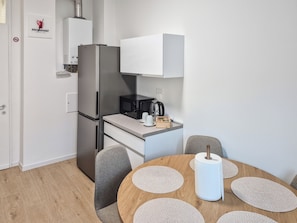 A compact kitchen with a refrigerator, microwave, and coffee maker.