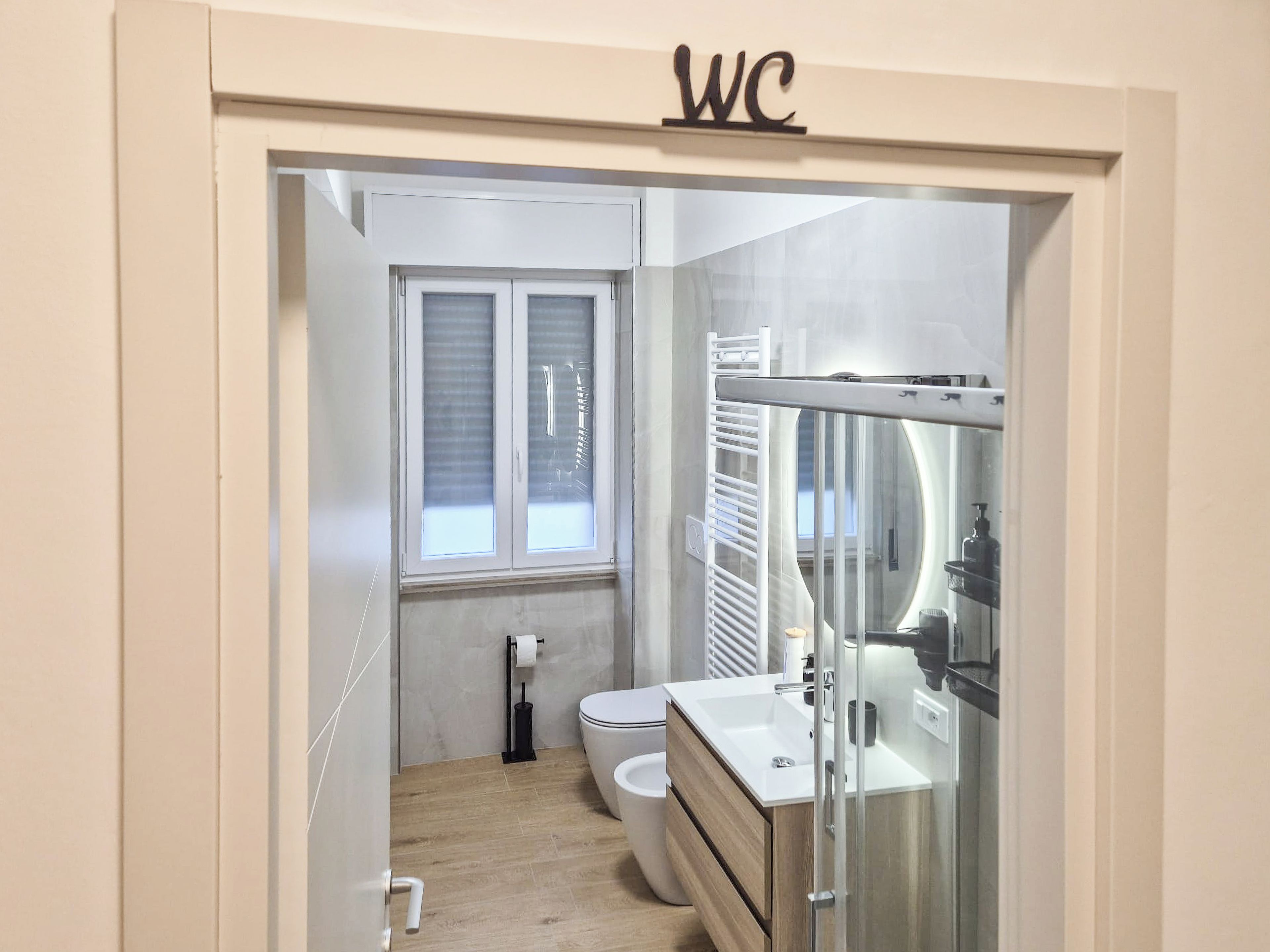 A modern bathroom with a toilet, a sink, and a glass shower enclosure.
