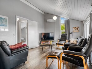 A modern living room with leather sofas, a flat-screen TV, and a wooden coffee table. - "Nandolf" - 200m to the fjord by Interhome (Vestervig)