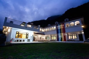 A multi-story building with a balcony and a well-lit entrance. - Li Wu Zuo Can B&B (Xiulin)