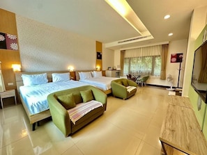 A hotel room with two beds, a sofa, a dining table, and a TV. - Li Wu Zuo Can B&B (Xiulin)