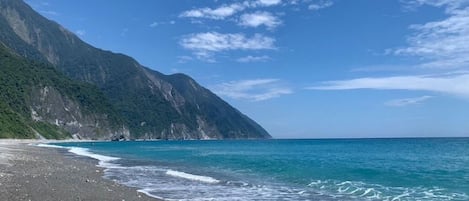 Una playa costera con montañas al fondo.