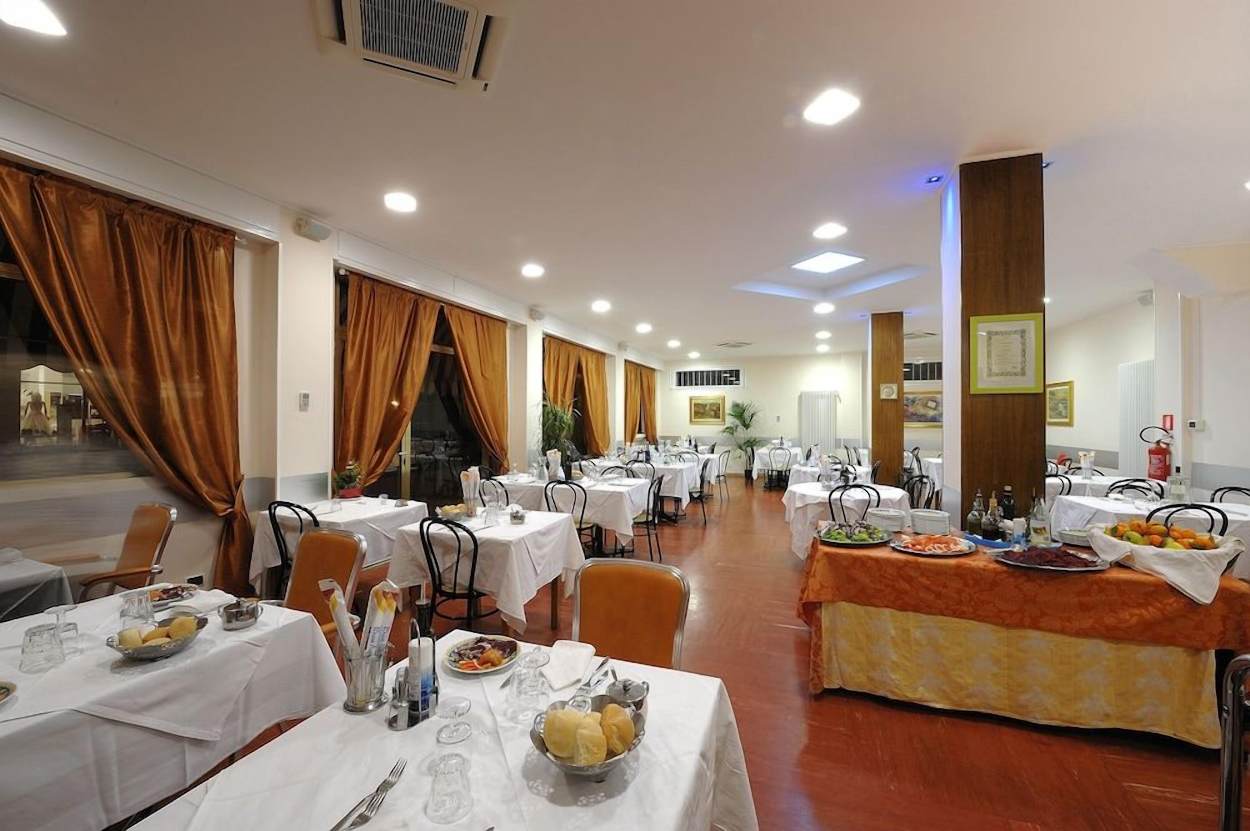 A dining area with multiple tables, chairs, and a buffet setup.
