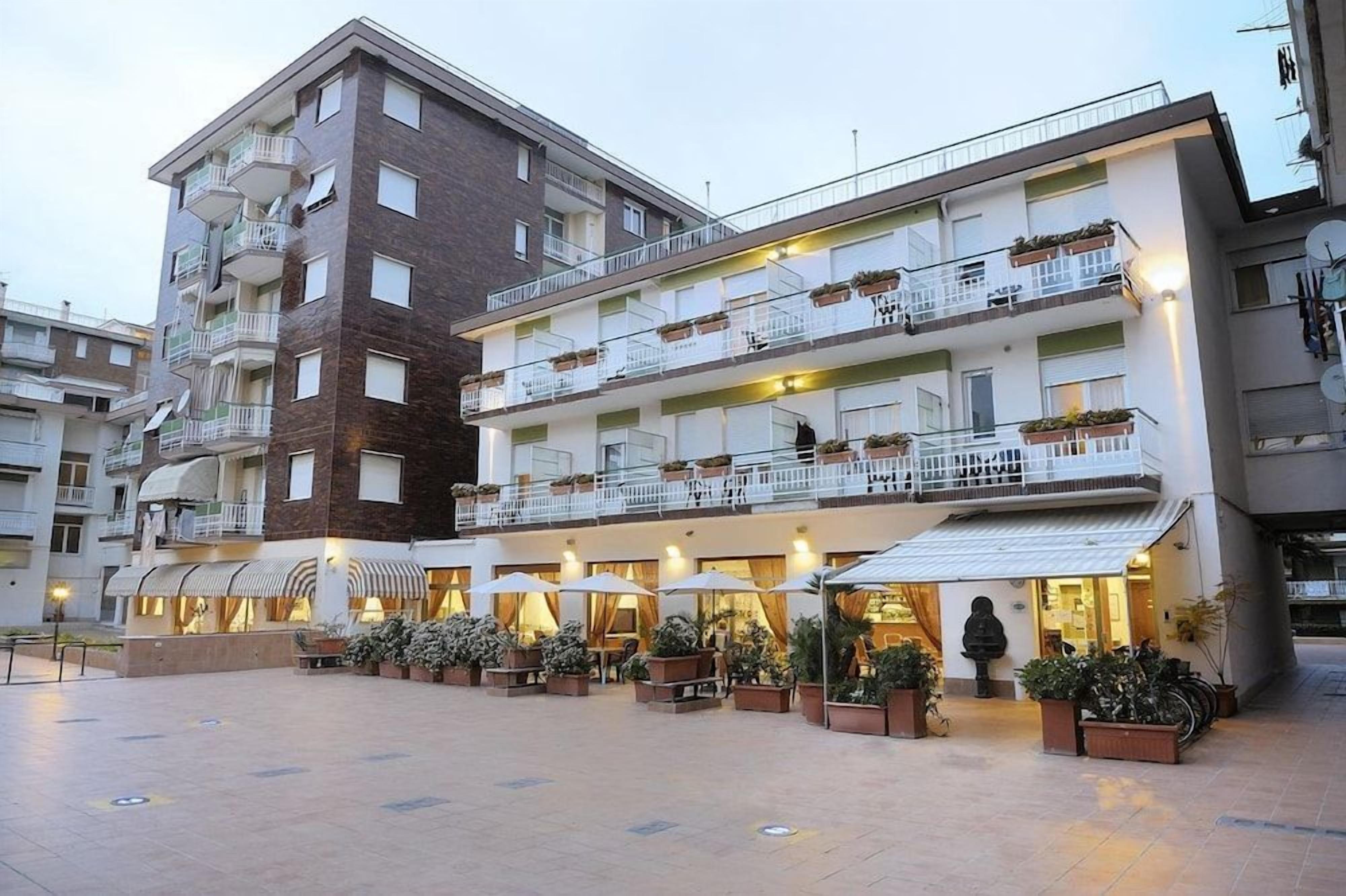 A multi-story hotel with outdoor seating and a courtyard.