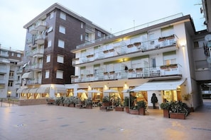 Un hotel a più piani con posti a sedere all'aperto e un patio coperto.