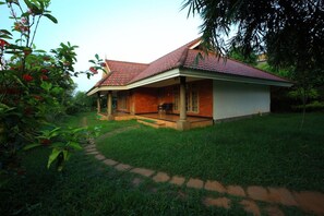 A house with a tiled roof, a porch, and a pathway leading to the entrance. - Arayal Resorts: A Unit of Sharoy Resort (Vythiri)