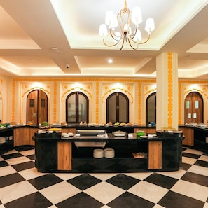 Un vestíbulo de hotel con piso a cuadros, un mostrador de recepción central y arcos decorativos.