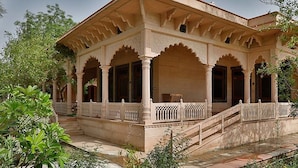 A traditional building with a covered porch, columns, and a staircase leading to the entrance. - Club Mahindra Bharatpur (Bharatpur)