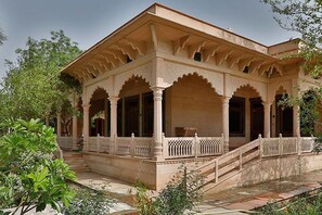 Un bâtiment de style traditionnel, doté d’un porche couvert, de colonnes et d’un escalier menant à l’entrée.