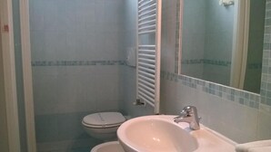 Kylpyhuone, jossa on wc, pesuallas ja peili.
