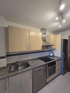 A modern kitchen with stainless steel appliances, a double sink, and light-colored cabinets. - 3 Bed Apartment - Sleeps 6 - Pool - Parking - Golf (Mijas)
