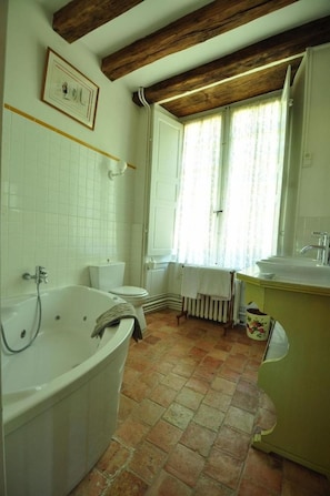 Une salle de bain avec une baignoire, des toilettes et un lavabo.