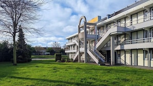 Un edificio moderno con varios balcones y una escalera central.