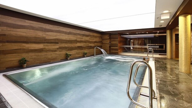 An indoor swimming pool with a wooden wall and a clear ceiling. - Aubrecht Country Resort And Spa (Przechlewo)