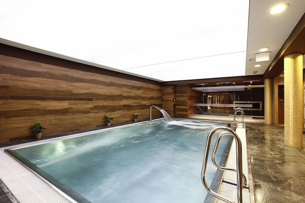 An indoor swimming pool with a wooden wall and a clear ceiling. - Aubrecht Country Resort And Spa (Przechlewo)