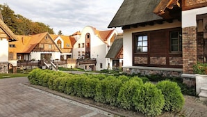 A traditional European-style building with a stone facade, wooden balconies, and a well-maintained garden area. - Aubrecht Country Resort And Spa (Przechlewo)