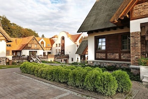 A traditional European-style building with a stone facade, wooden balconies, and a well-maintained garden area. - Aubrecht Country Resort And Spa (Przechlewo)