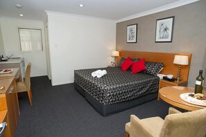 Una camera d'albergo con un letto, comodini, una scrivania e una sedia.