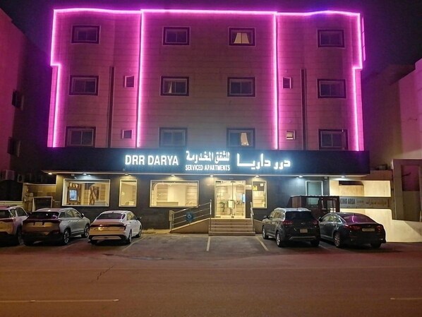 A building with a sign for 'DHR DARYA Serviced Apartments' and a parking area with several cars. - Dorar Darea Hotel Apartments Al Malqa 2 (Riyadh)