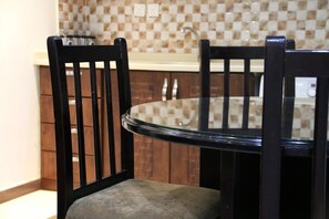 A dining area with a glass table and two black chairs. - Dorar Darea Hotel Apartments Al Malqa 2 (Riyadh)