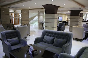 A lobby with sofas, a coffee table, and a staircase in the background. - Dorar Darea Hotel Apartments Al Malqa 2 (Riyadh)