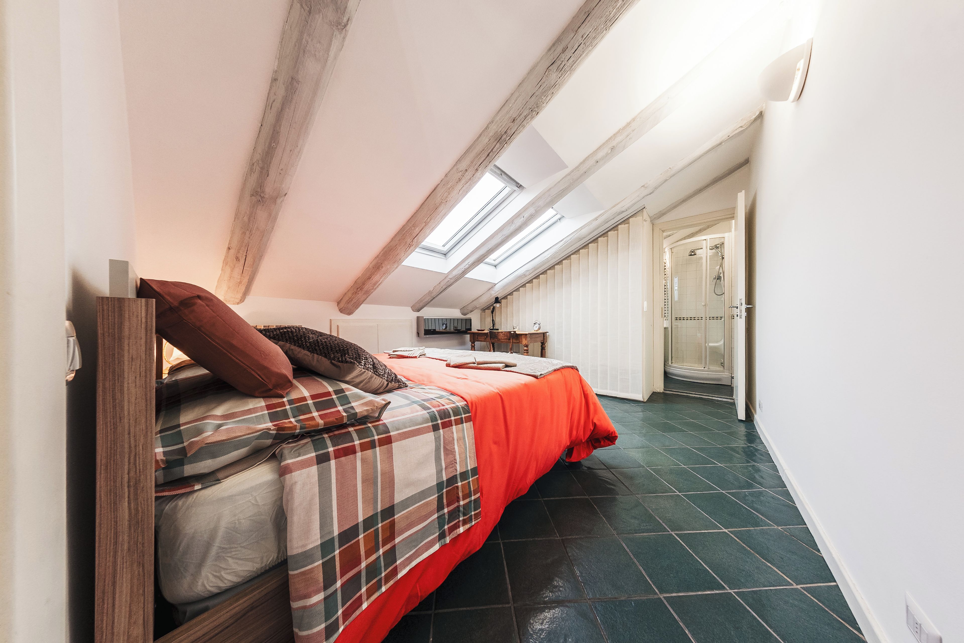 Ein Schlafzimmer mit Schlafkoje, Dachfenster und Dusche.