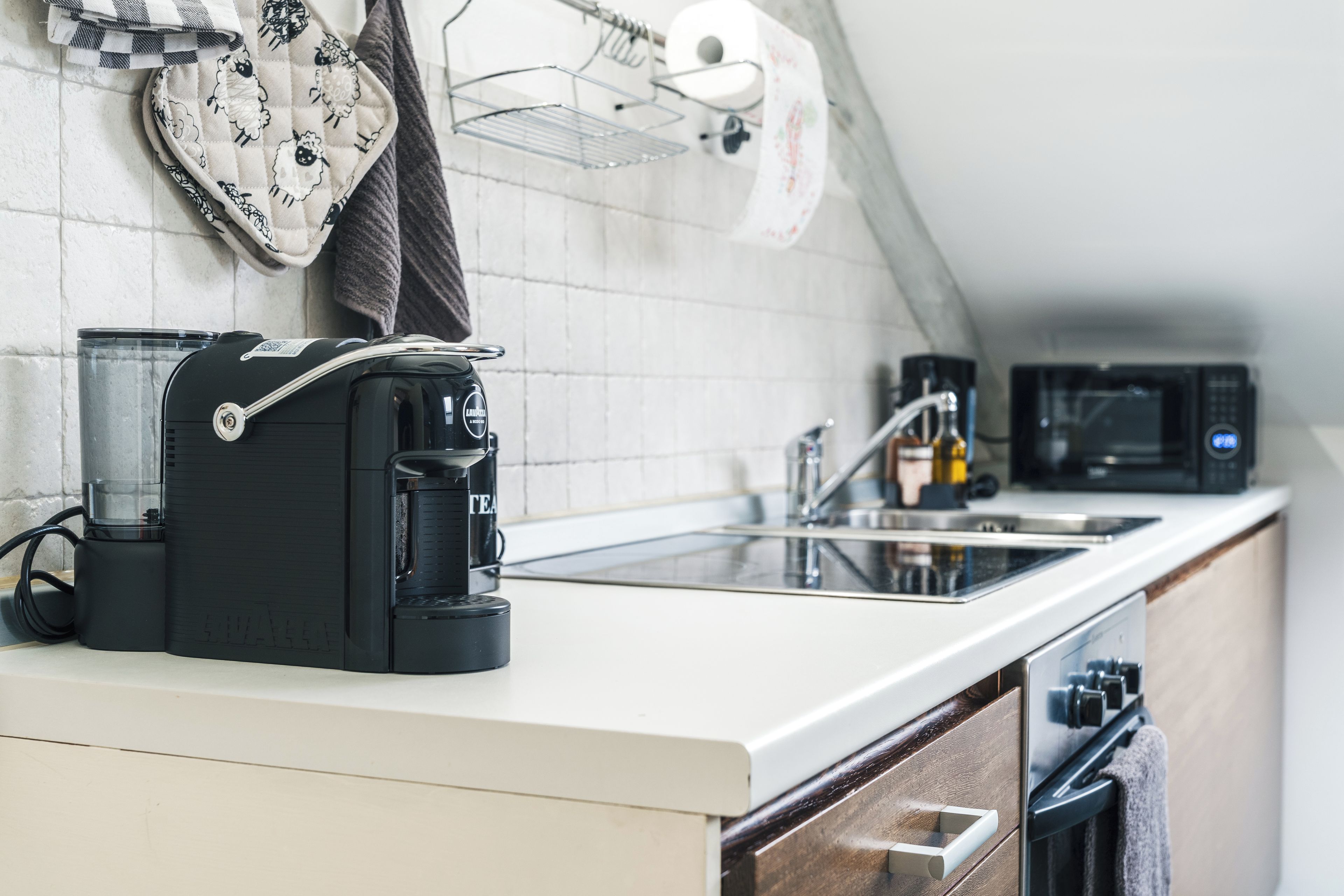 Eine Küche mit Kaffeemaschine, Mikrowelle und Spüle.