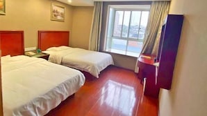 A hotel room with two beds, a window with curtains, a nightstand with a phone, and a wall-mounted TV. - Greentree Inn Jiangxi Ganzhou Sankang Temple Darunfa Express Hotel (Ganzhou)