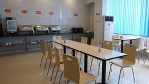 A modern dining area with tables and chairs, a coffee machine, and a refrigerator. - Greentree Inn Jiangxi Ganzhou Sankang Temple Darunfa Express Hotel (Ganzhou)