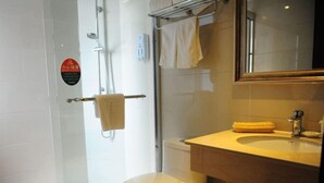 A modern bathroom with a glass shower enclosure, a toilet, and a sink with a towel. - Greentree Inn Jiangxi Ganzhou Sankang Temple Darunfa Express Hotel (Ganzhou)