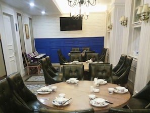 A dining area with round tables and chairs, a flat-screen TV mounted on the wall, and a chandelier. - Greentree Inn Yancheng Jianhu Shanggang Bus Station Freeway 204 Express Hotel (Yancheng)