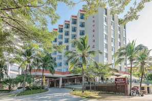 A multi-story hotel with a covered entrance and outdoor seating area. - South China (Sanya)