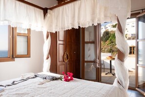 Un dormitorio con cama, ventana, puerta y vistas al exterior.