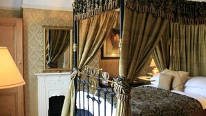 A four-poster bed with draped curtains, a fireplace, a mirror, and a bedside table with a lamp. - The Old Registry Haworth - Guest House (Keighley)