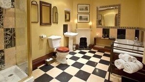 A bathroom with a checkered floor, a toilet, a sink, a mirror, and a shower area. - The Old Registry Haworth - Guest House (Keighley)