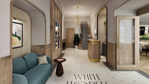 A hallway with a sofa, a patterned floor, a staircase, and a door leading to a dining area. - White Horse Hotel (Brighton)