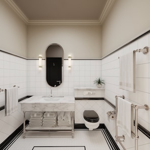 A modern bathroom with a marble sink, black toilet, and a mirror with wall sconces. - White Horse Hotel (Brighton)