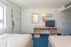 A hotel room with two beds, a desk with a television, a mirror, and a window. - Gazelle Stay by Hotel O Socorro (Socorro)